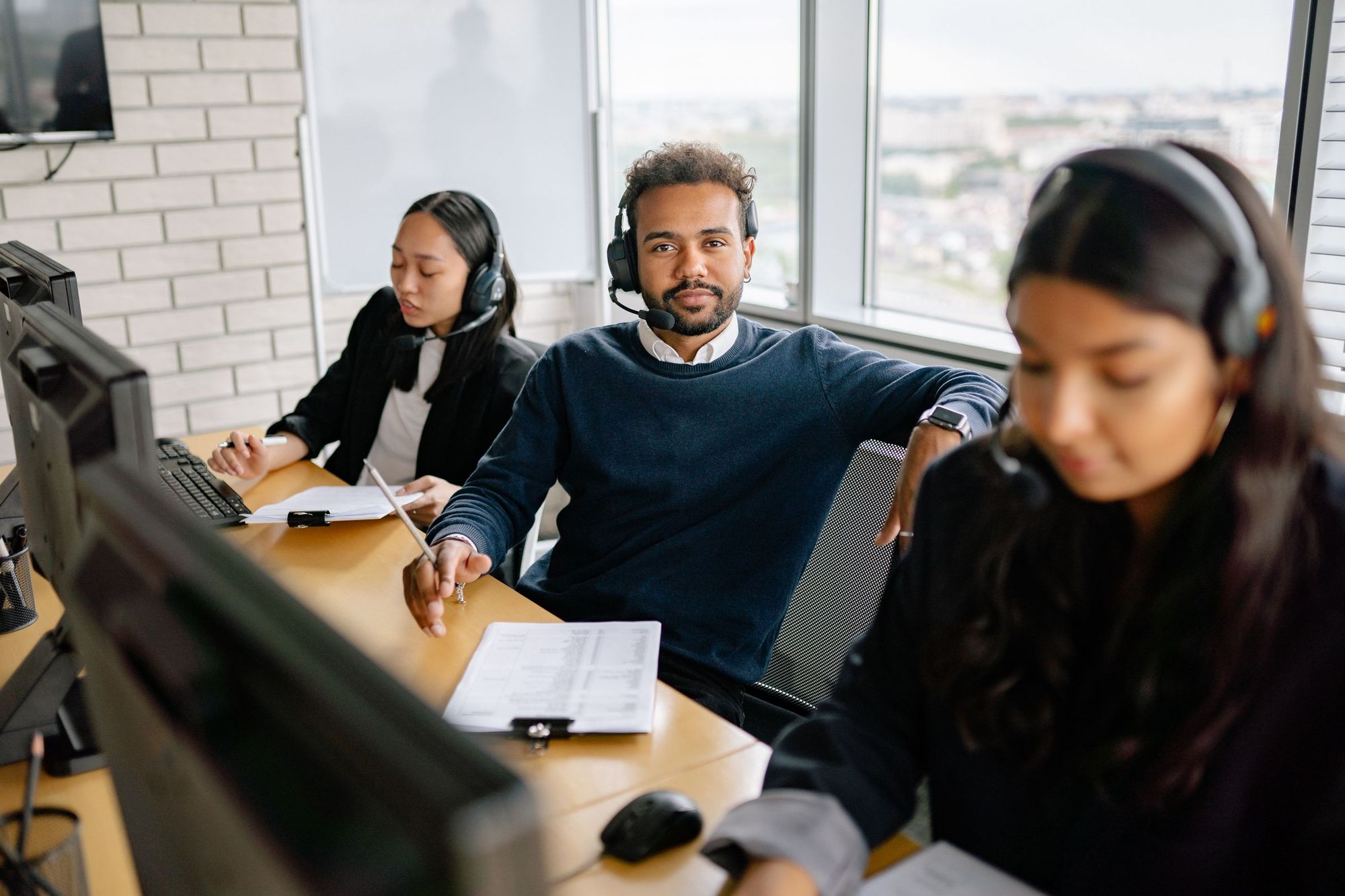 An IT support team with headsets at their desks