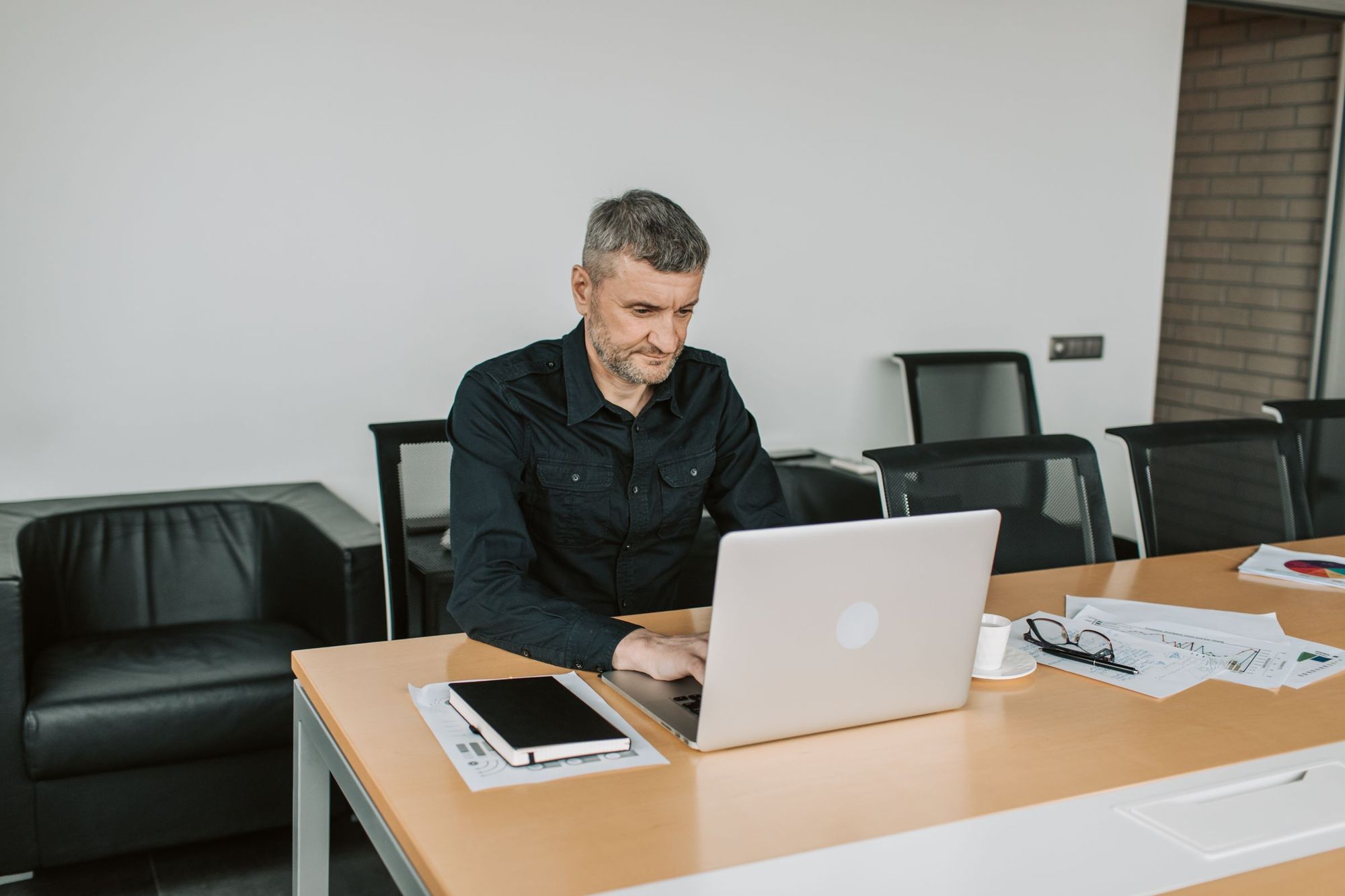 A man working at a laptop in a meeting room